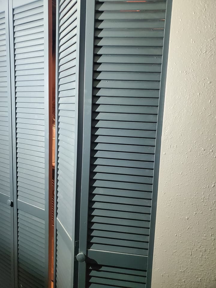 Installed green and white louvered vents mounted on an interior wall