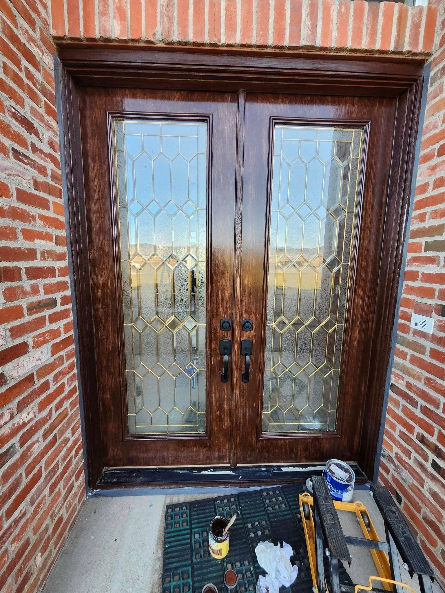 Installed dark wood double doors with geometric glass panes