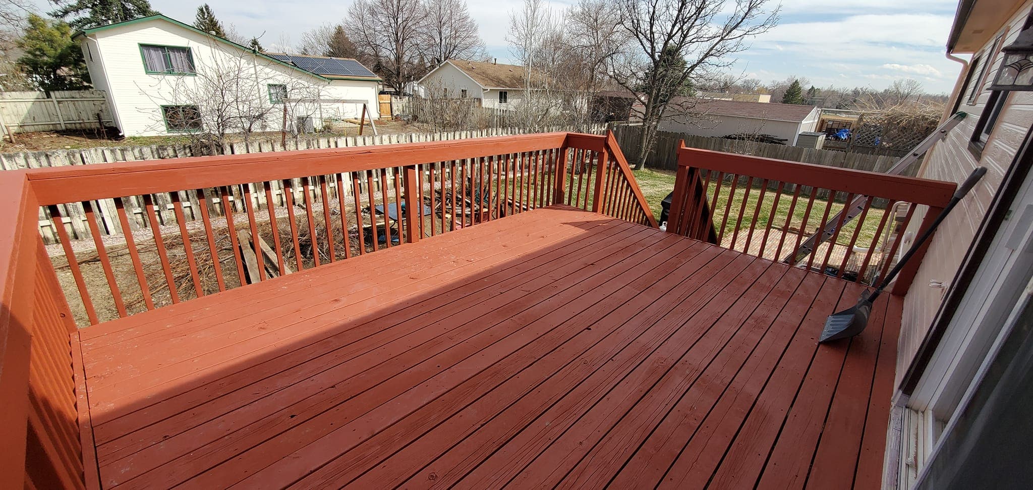 Newly stained wooden deck with white railings
