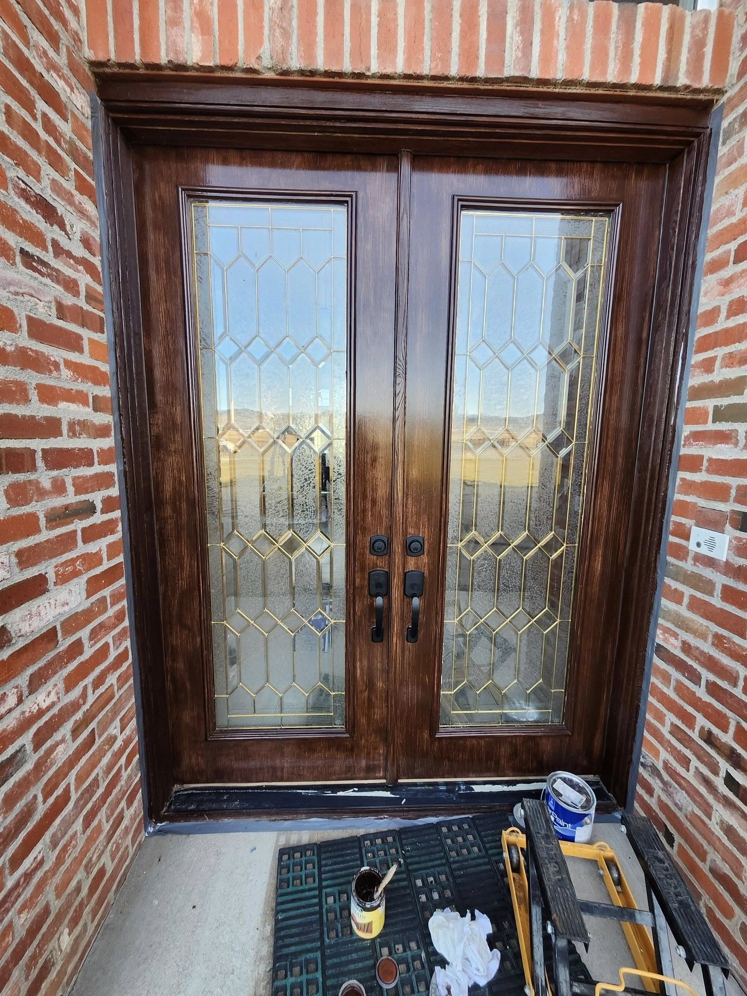 Installed dark wood double doors with geometric glass panes