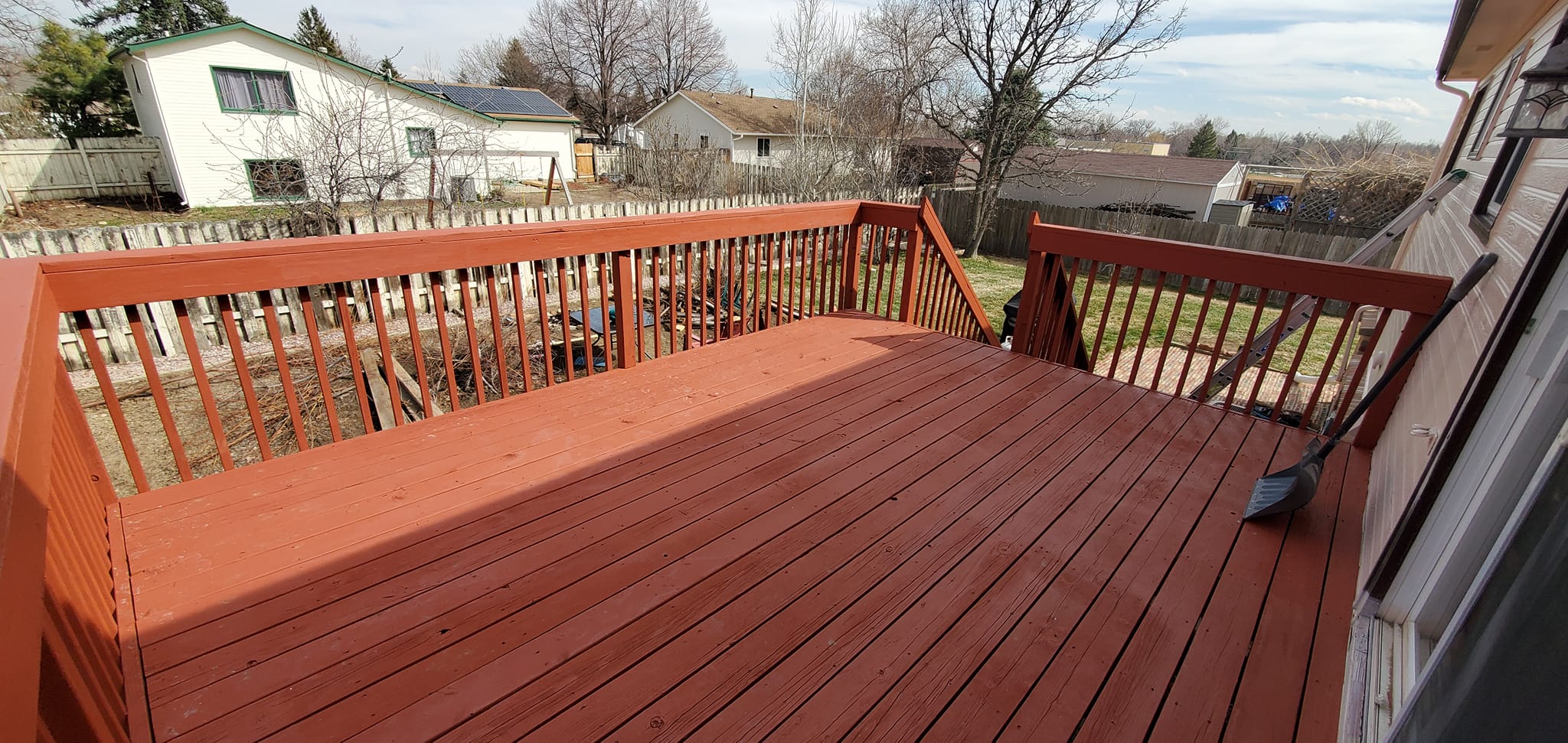 Newly stained wooden deck with white railings