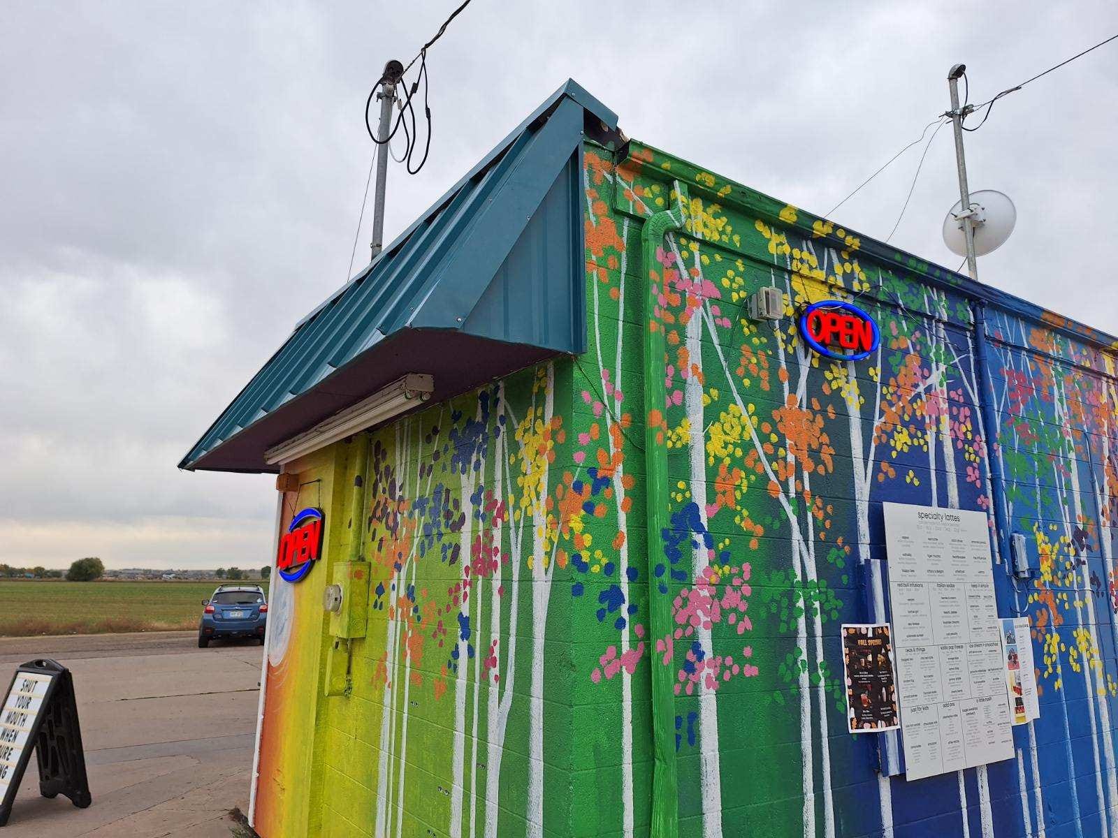 Bright green and blue food cart with colorful floral mural