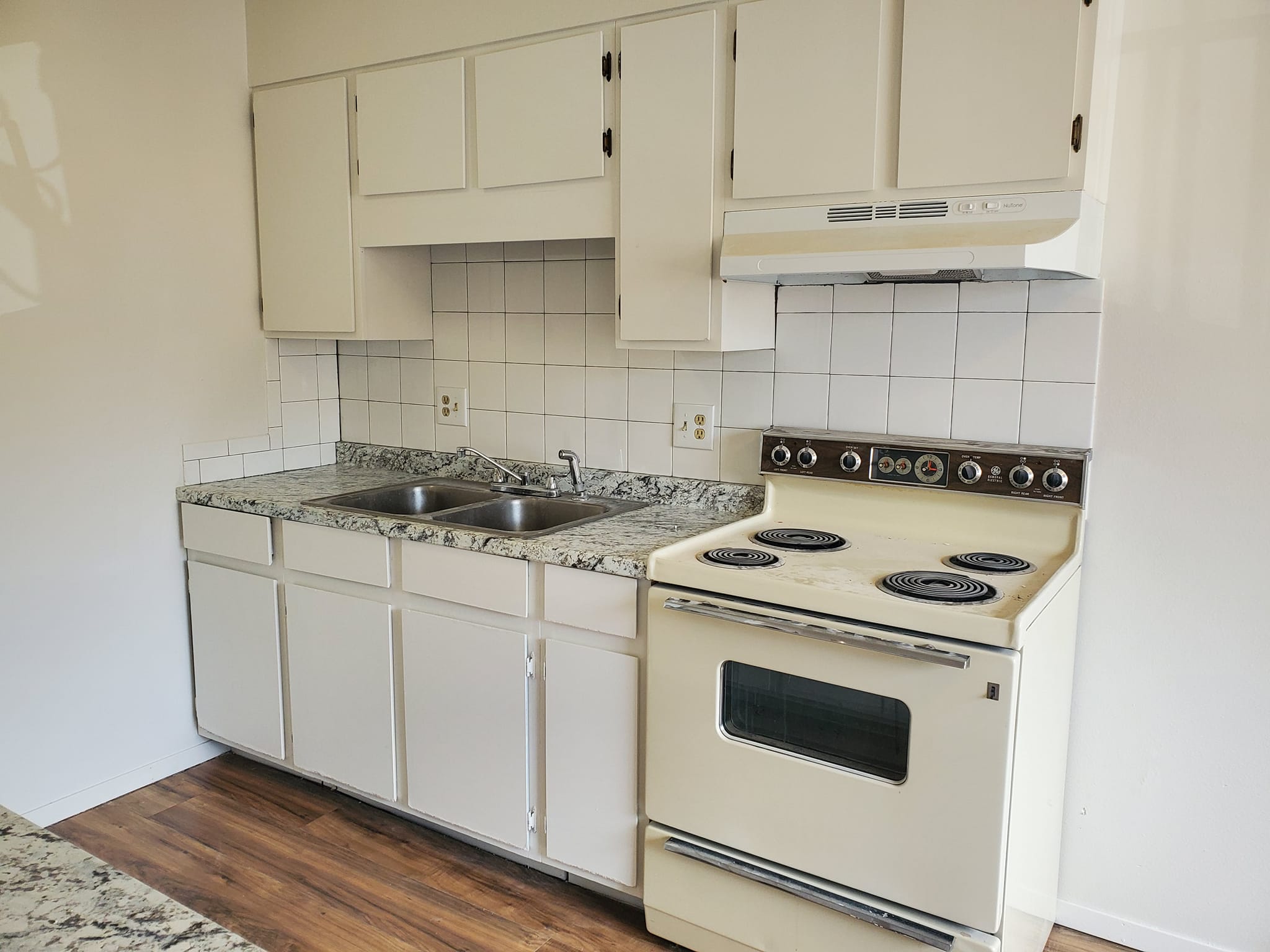 Completed kitchen with white cabinetry and tile backsplash